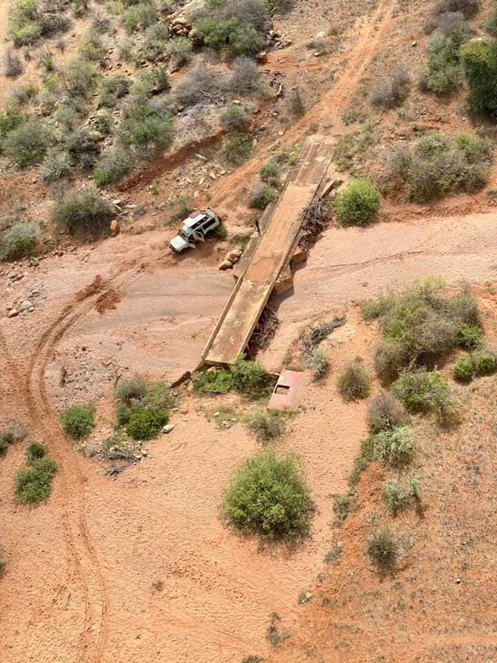Aerial view of a safari vehicle crossing a dry riverbed