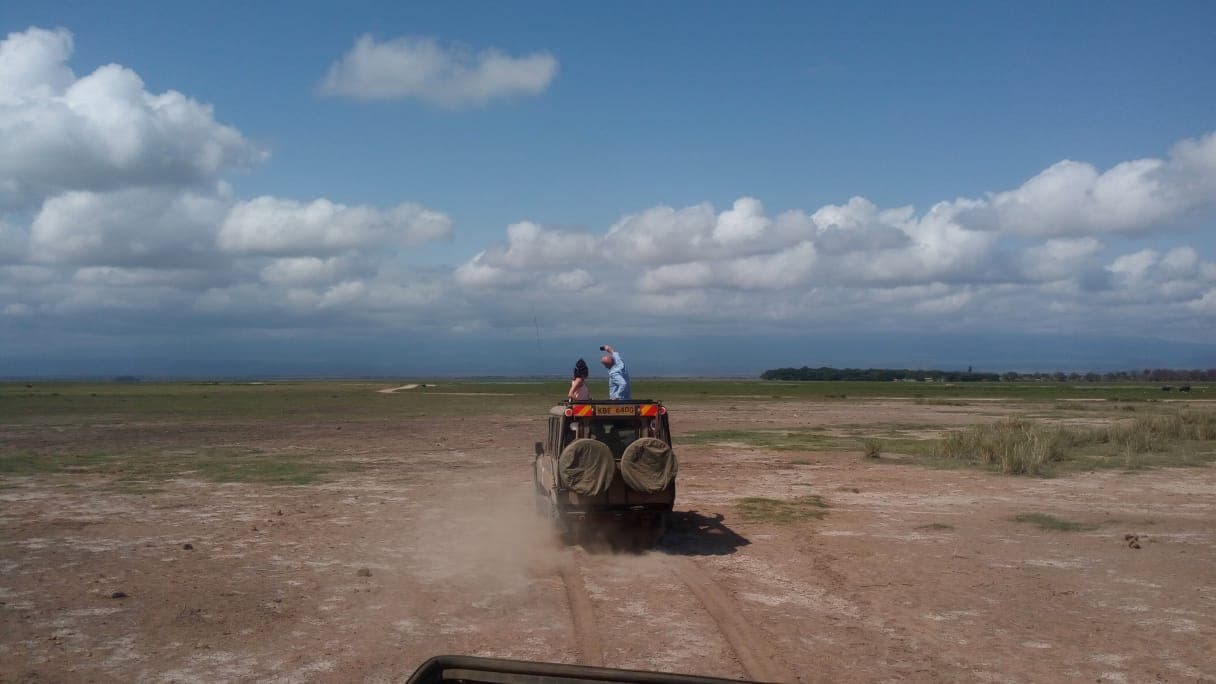 Safari vehicle crossing the dry lakebed in Amboseli